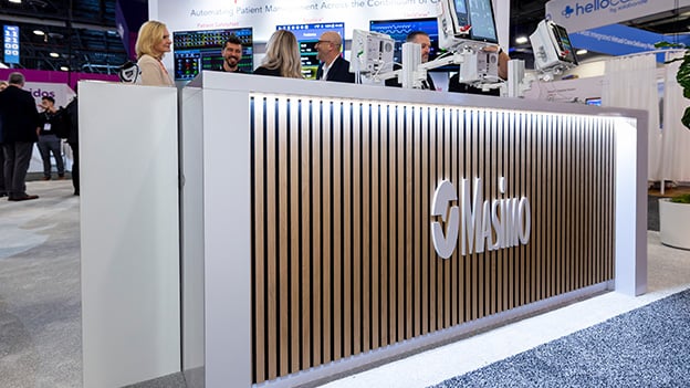 Trade show exhibit reception desk for Masimo with product displays and team interaction